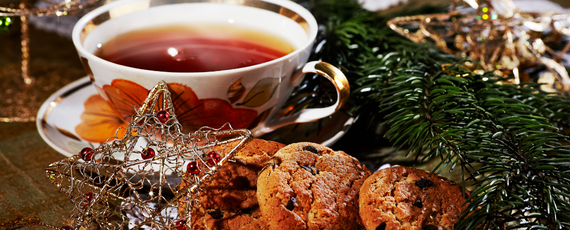 Red tea in a white cup with a star ornament and cookies