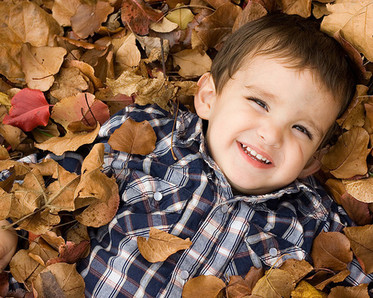 Boy in Fall leaves, photo by Brandon Doan/Flikr