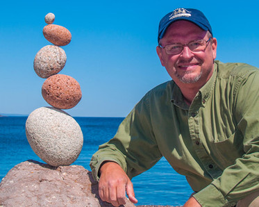Instructor Peter Juhl with a balanced stone sculpture