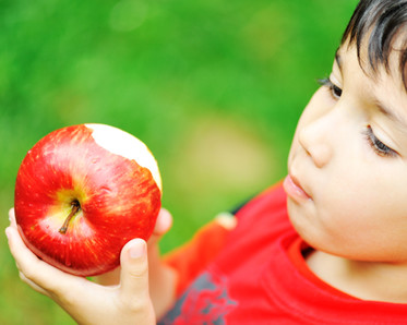 boy tasting an apple, photo courtesy of Storyblocks