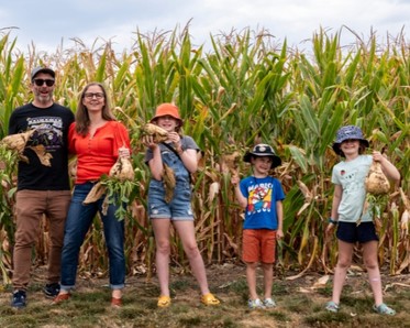Family standing in front of corn