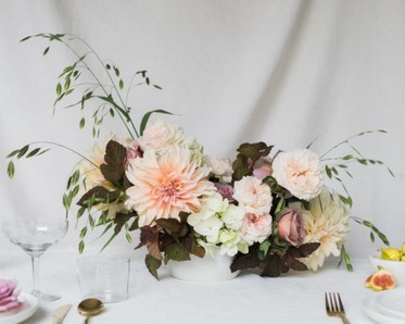 floral centerpiece with greens in peach and cream colors