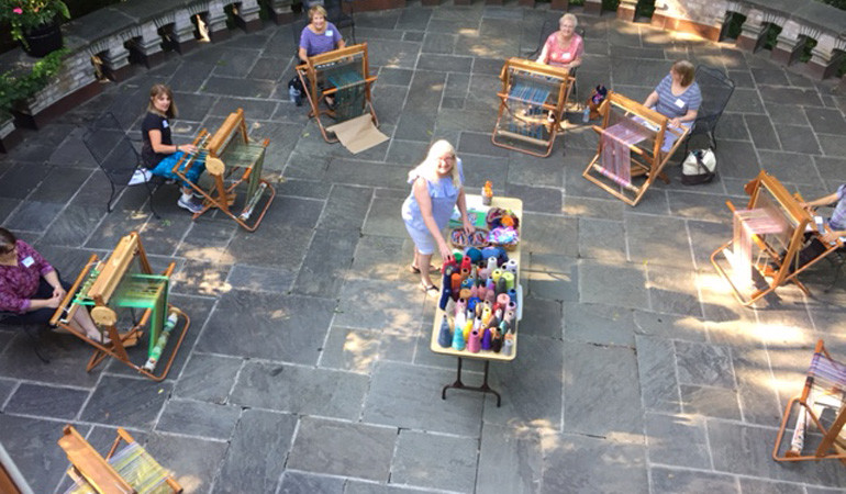 SAORI students using their looms outside on the Tea Room Terrace