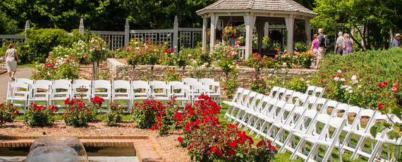 White chairs gathered around a fountain with a gazebo in the background