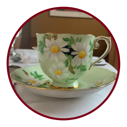 Green tea cup on a plate with white daisy design