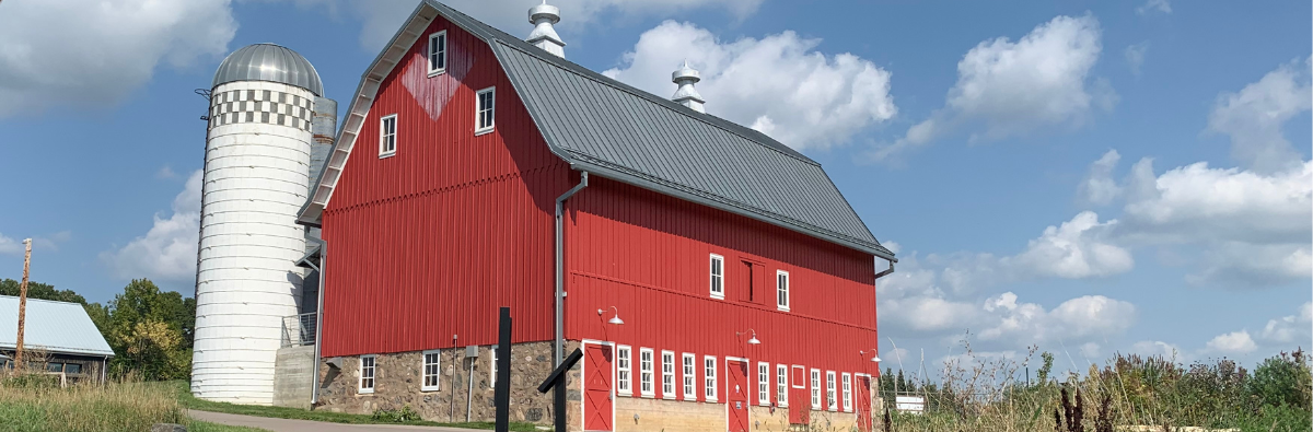 Red Barn and white silo with blue sky background
