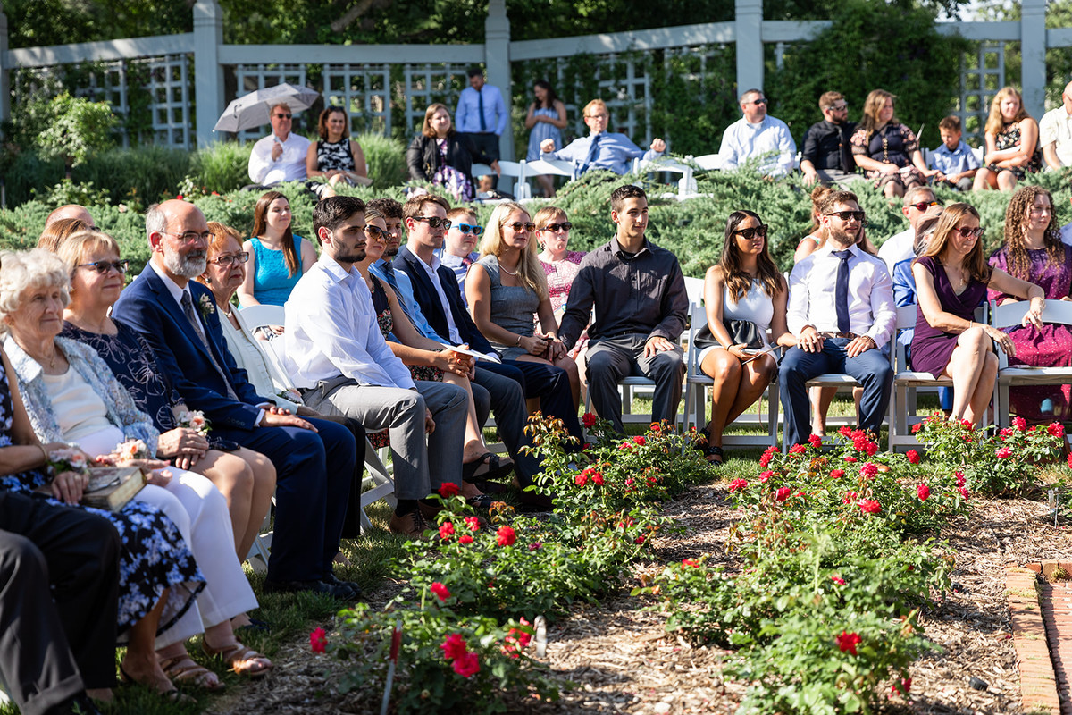 People gathered in the rose garden to watch a wedding